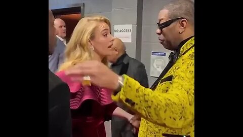 Adele & Busta Rhymes giving each other their flowers at the Grammys