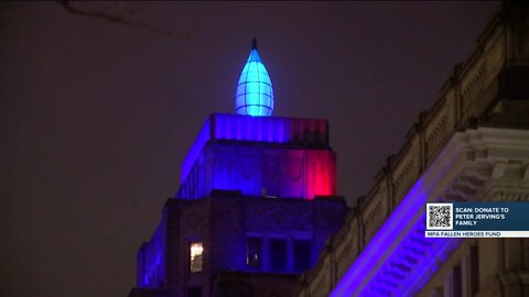 City landmarks shine in blue in honor of fallen police officer
