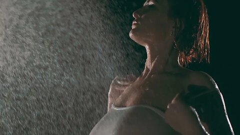 Mulher peituda tomando banho na mangueira com a blusa transparente