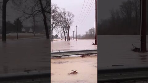 Flooded road over river bridge. Driving over through the water