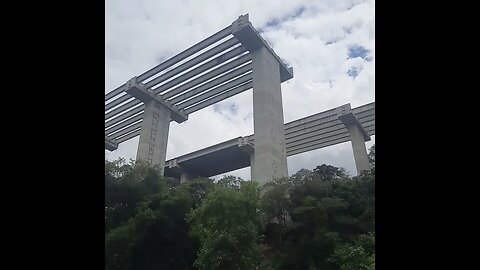 VISUAL DA RUA PERTO ESQUELETO DO RODOANEL NORTE COM PIXAÇÕES E LIXO DA OBRA ABANDONADA