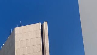 Man climbing on a Chase Tower in Phoenix, Arizona has made it to the top of the building
