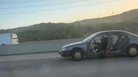 Car Missing All Four Doors Driving on Highway