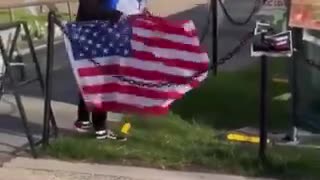 A student protester tears down an American flag at the MIT campus and discards it...