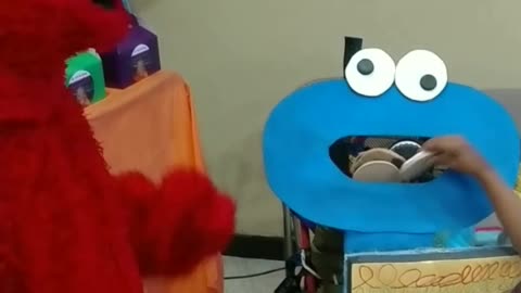 Feed cookies to cookie monster game with Elmo at a birthday party in Houston Texas