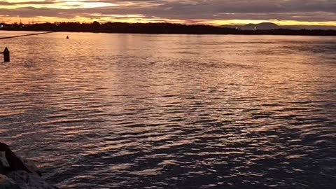 Quiet sea and fishermen at sunset