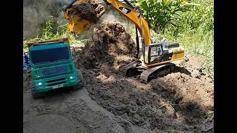 RC Excavator fills soil to green dump truck