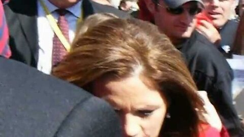 Michele Bachmann surrounded as she leaves.AVI