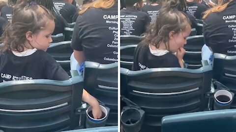 Little girl sticks her hand in random cup of soda at baseball game