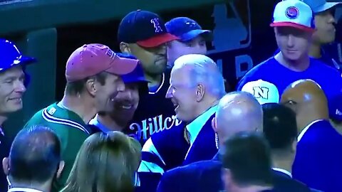 Maskless Joe Biden meets and shakes hands with attendees at Nationals Stadium at baseball game.