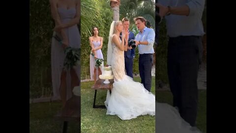 Mean bride sits on the wedding cake