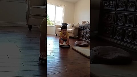 Little Boy Rides a Roomba Vacuum