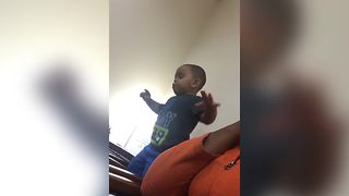 A Tot Boy Falls Off Of A Chair And Lands With His Legs In The Air