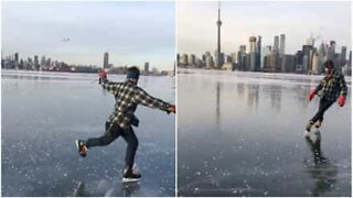 Man performs ice skating tricks on frozen Toronto lake