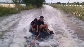 Du wake-board sur une route inondée de Thaïlande