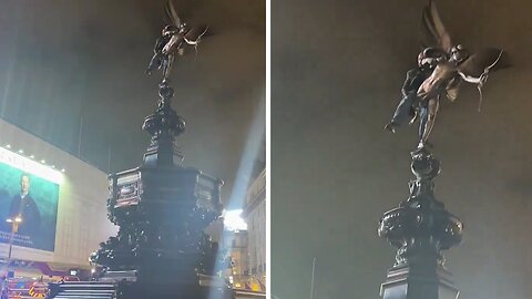 Man get stuck on the Eros statue in Piccadilly Circus