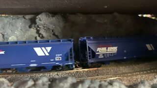 N Scale grain train climbs though tunnel with helpers