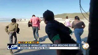 Dozens of migrants breach border wall in San Diego