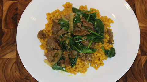 Turmeric barley with caramelized onion, beef and spinach