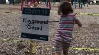 Criança tenta destruir placa que avisa que o parque está fechado