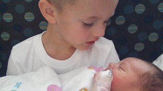 Little boy meets newborn baby brother