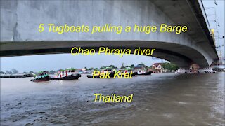 5 Tugboats pulling a huge barge at Pak Kret Chao Phraya river in Thailand