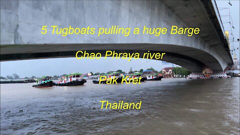 5 Tugboats pulling a huge barge at Pak Kret Chao Phraya river in Thailand