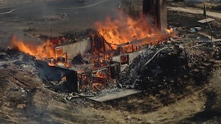 Fire destroys home and spreads to grass field