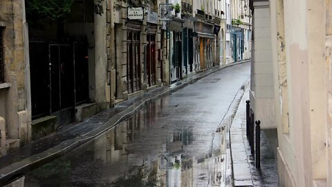 Rain in puddles on picturesque Rue de Bièvre in Paris, France