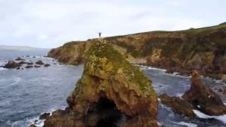 Explorador aventura-se em majestoso penhasco na Irlanda