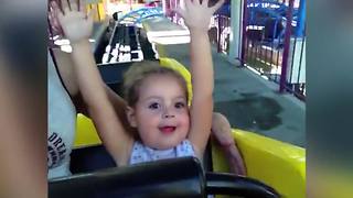 A Tot Girl Is Excited And Shocked As She Rides Her First Roller Coaster
