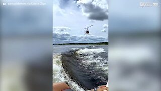 Jovem salta de helicóptero para prancha de surf