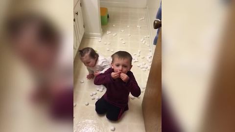 Tot Boy And Baby Girl Are Having Cotton Balls Party In A Bathroom