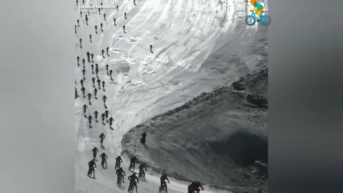 Hundreds of riders hurtle down an icy cliff and crash.