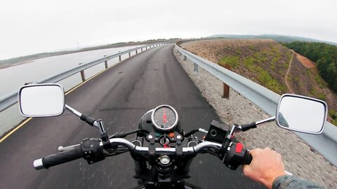 A Motorcycle Rider Traveling On The Dam Wall Built As Road