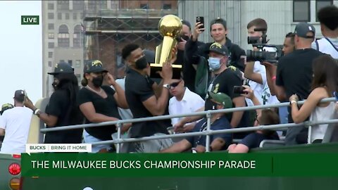 Giannis hoists the Larry O'Brien trophy during parade