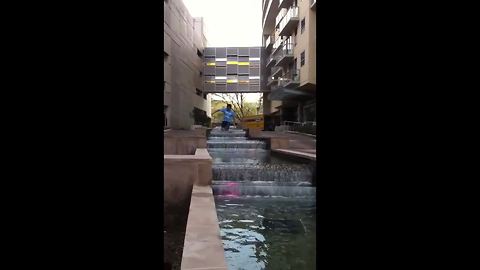 Young Man Walks Through A Fountain