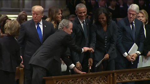 George W. Bush hands Michelle Obama a piece of candy at funeral for George H.W. Bush