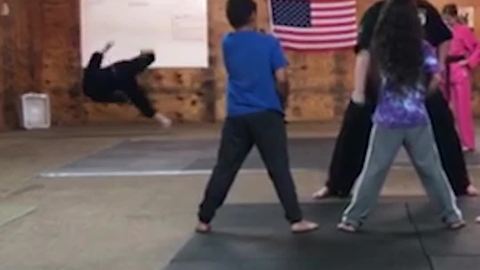 Guy Falls in The Background of Karate Practice Video