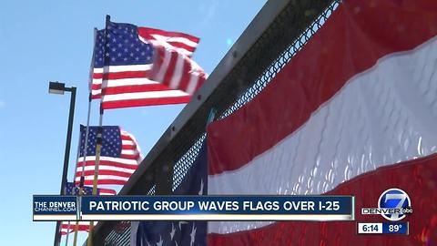 Patriotic group waves flags over I-25