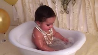 Birthday baby splashes in tub for priceless photo session