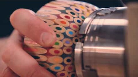 Talangfull konstnär gör en skål av 198 färgpennor