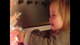 Little Girl is Amazed by her Glowing Christmas Tree
