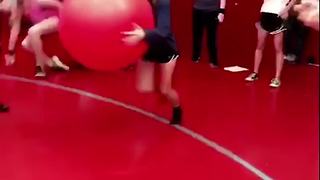 A Teen Boy And Girl Run At Each Other With Exercise Balls