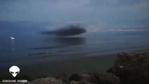 spicious looking cloud hovering right above the oceans surface during sun set in Ecuador.