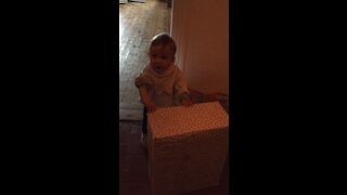 Extremely happy and excited baby because of huge wrapped birthday present