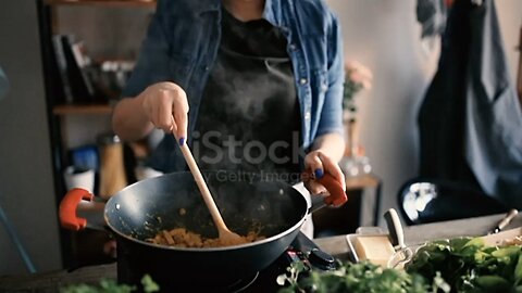 Young adult preparing dinner in kitchen from his home. He uses some ingredients and spices