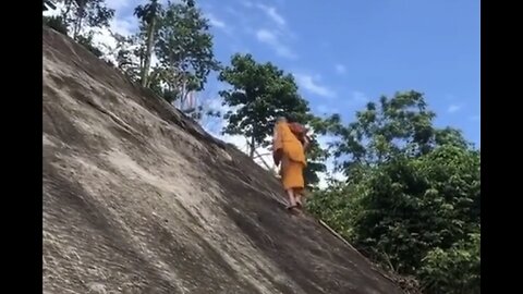 Monk Walks Up Steep Cliff With Ease