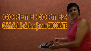 Gorete Cortez cobrindo bolo de laranja com chocolate .