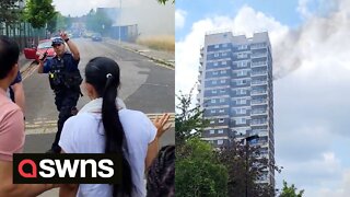Police seen disperse bystanders after fire breaks out at top of 17-storey London tower block